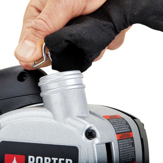 Close-up of a hand attaching a dust bag to the PORTER-CABLE 352VS power tool, with the tool's metallic dust outlet and fabric dust bag visible.