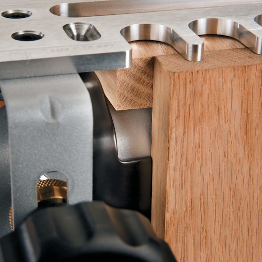 Close-up view of a PORTER-CABLE woodworking tool, showing metal components and a piece of wood positioned for precise work.