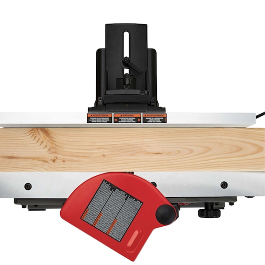 A PORTER-CABLE jointer, model PC160JT, shown from the front with a piece of wood placed on the machine's table. The jointer has a red safety guard and warning labels visible on the front side.