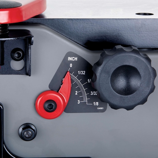 Close-up of a thickness adjustment gauge on a PORTER-CABLE jointer, showing a red pointer, a black adjustment knob, and an inch scale for precision measurements.
