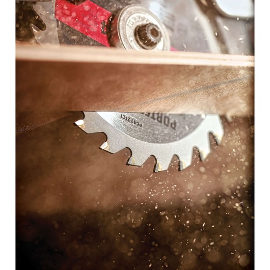 Close-up image of a PORTER-CABLE circular saw blade (SKU: PC412TCT) cutting through a piece of wood, with wood dust and debris visible in the foreground.
