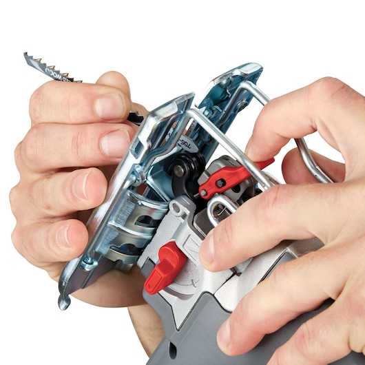 Close-up view of hands installing a saw blade into a PORTER-CABLE power tool, featuring metal and plastic parts with red adjustment levers.